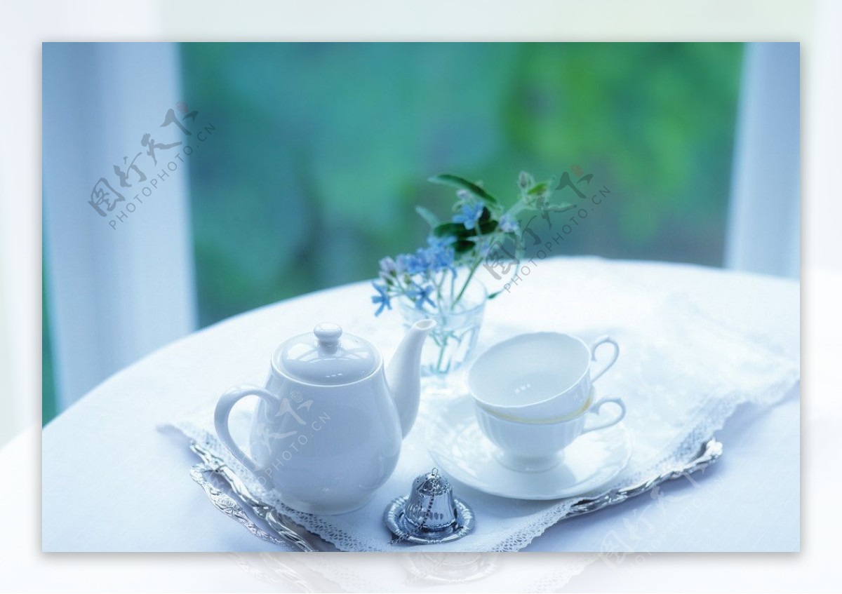 室内圆桌上的茶杯茶壶鲜花图片
