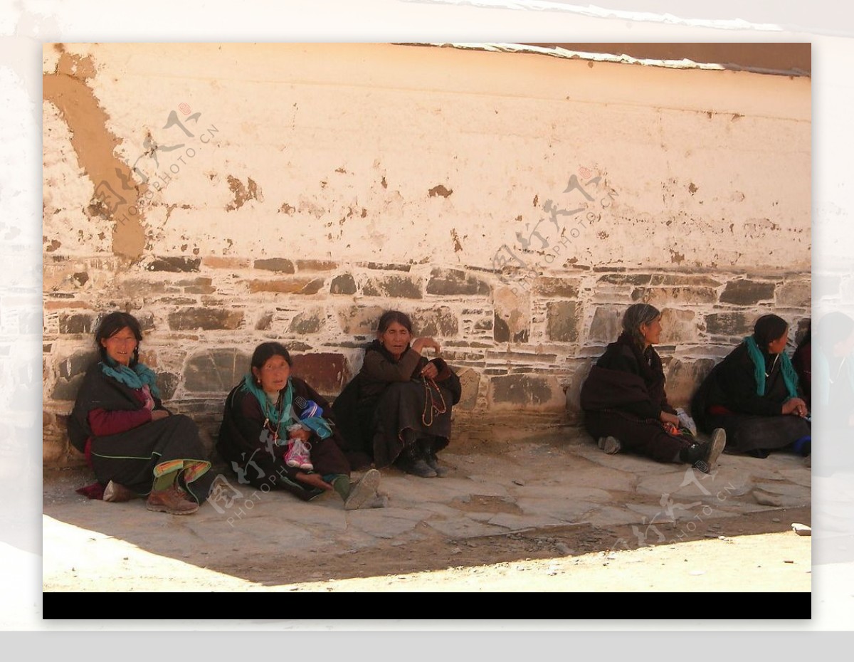 拉卜楞寺高墙下坐着的喇嘛教信徒们图片