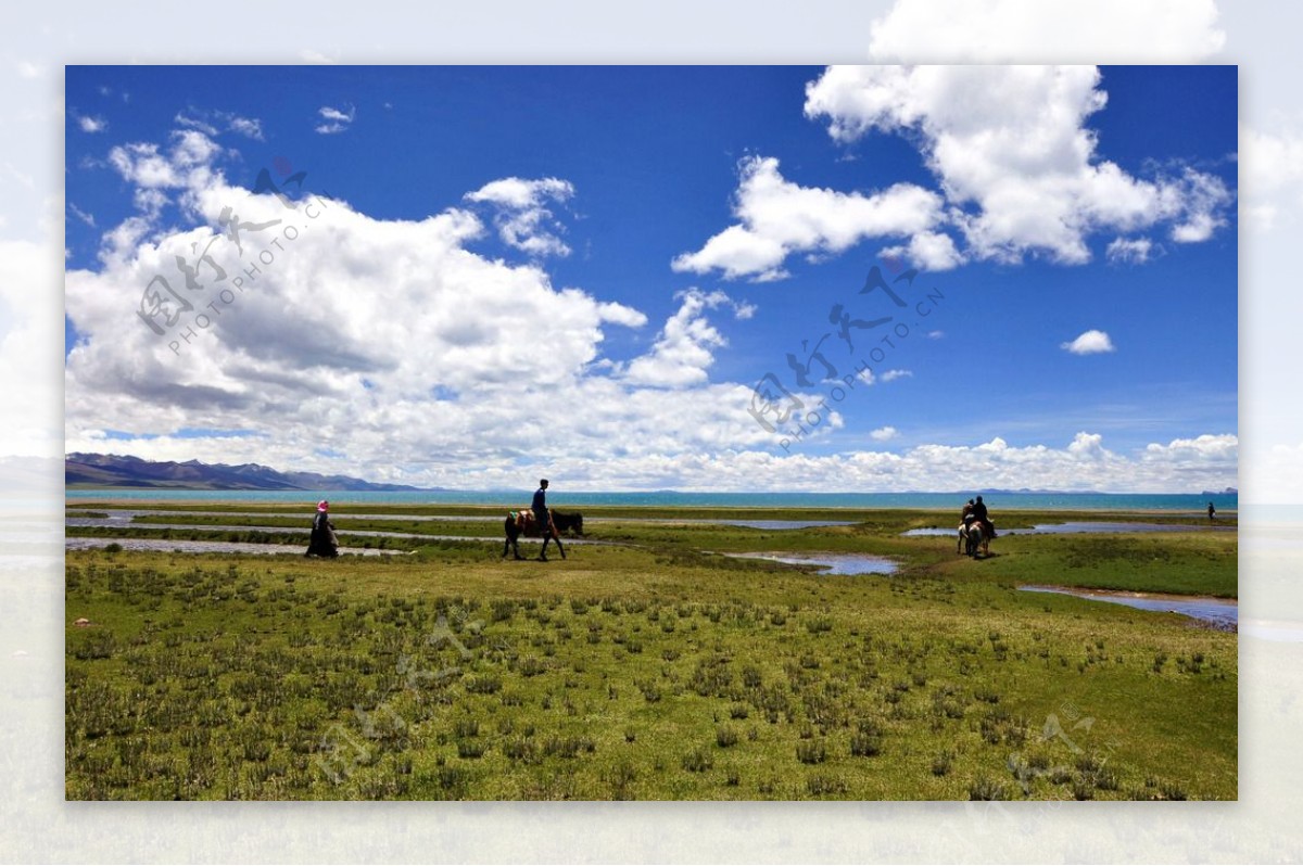 蓝天白云草原湿地骑马人图片