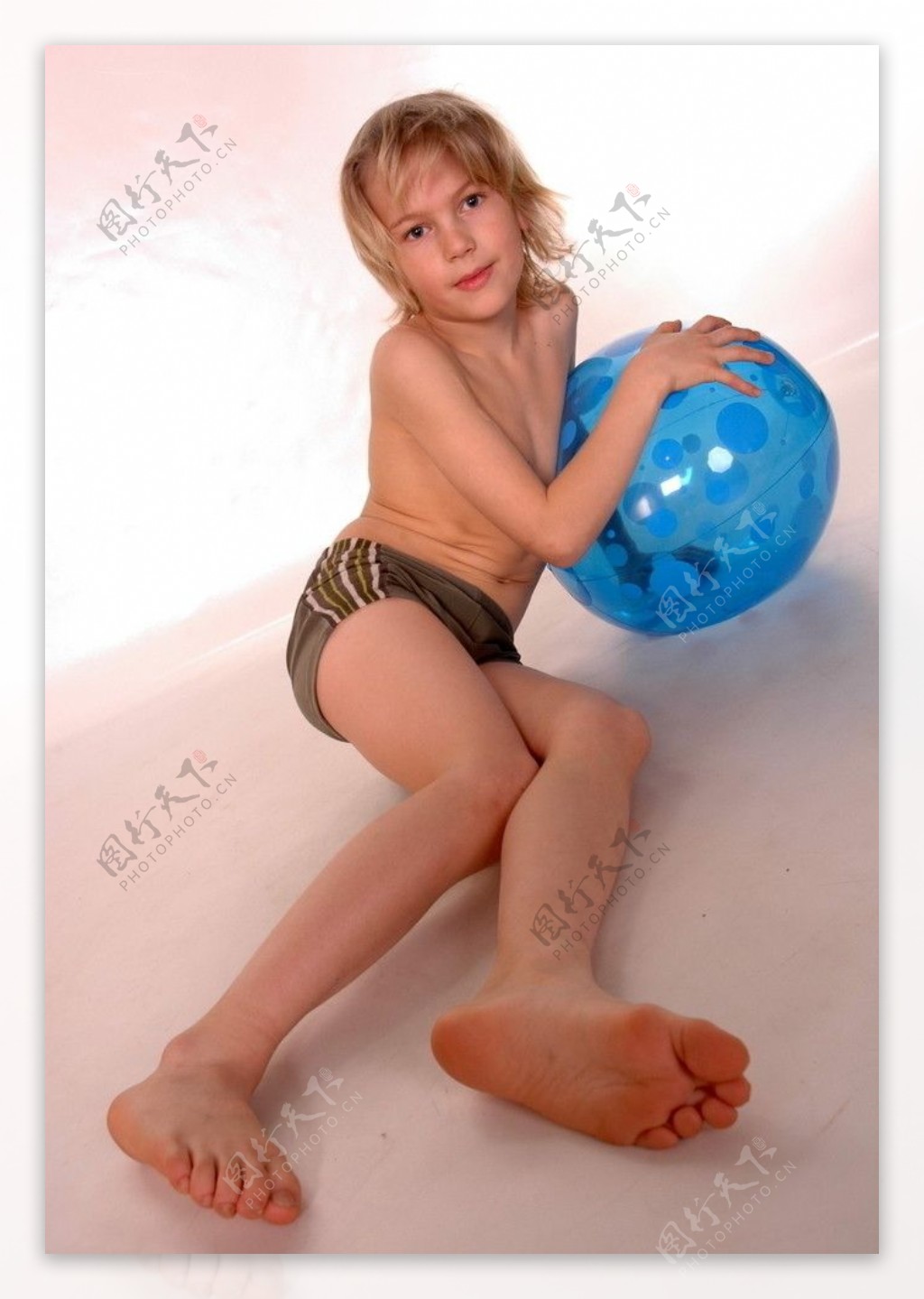 在地板上拿着充气球的男孩图片