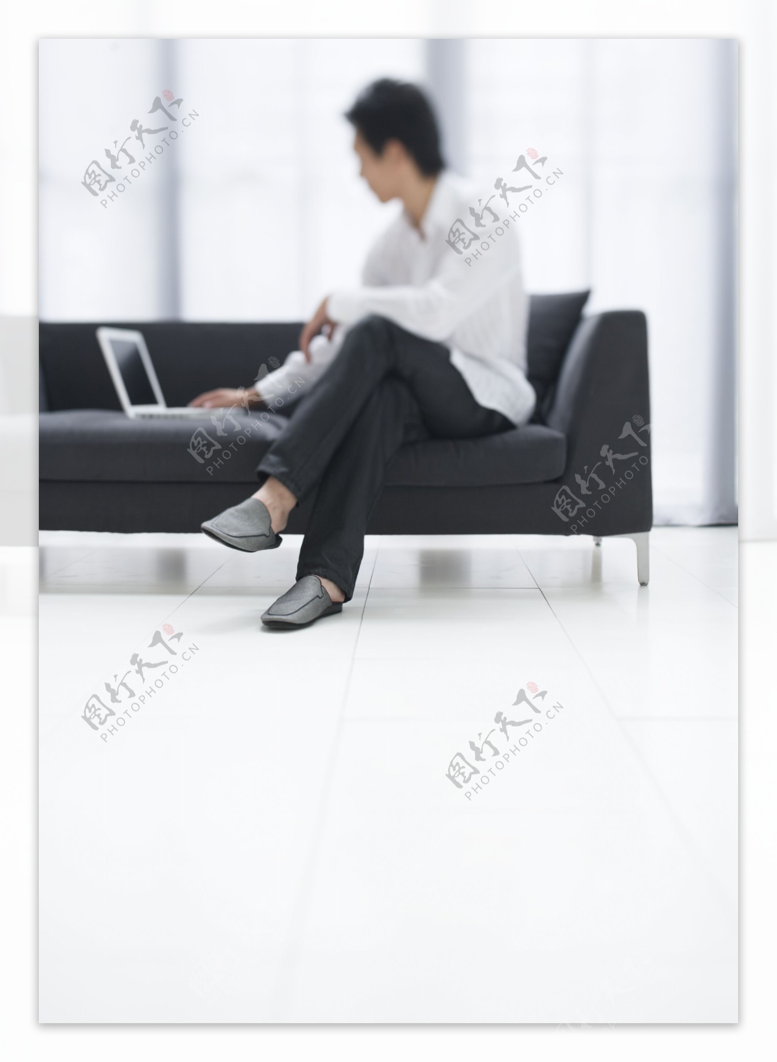 坐在沙发上玩电脑的男人