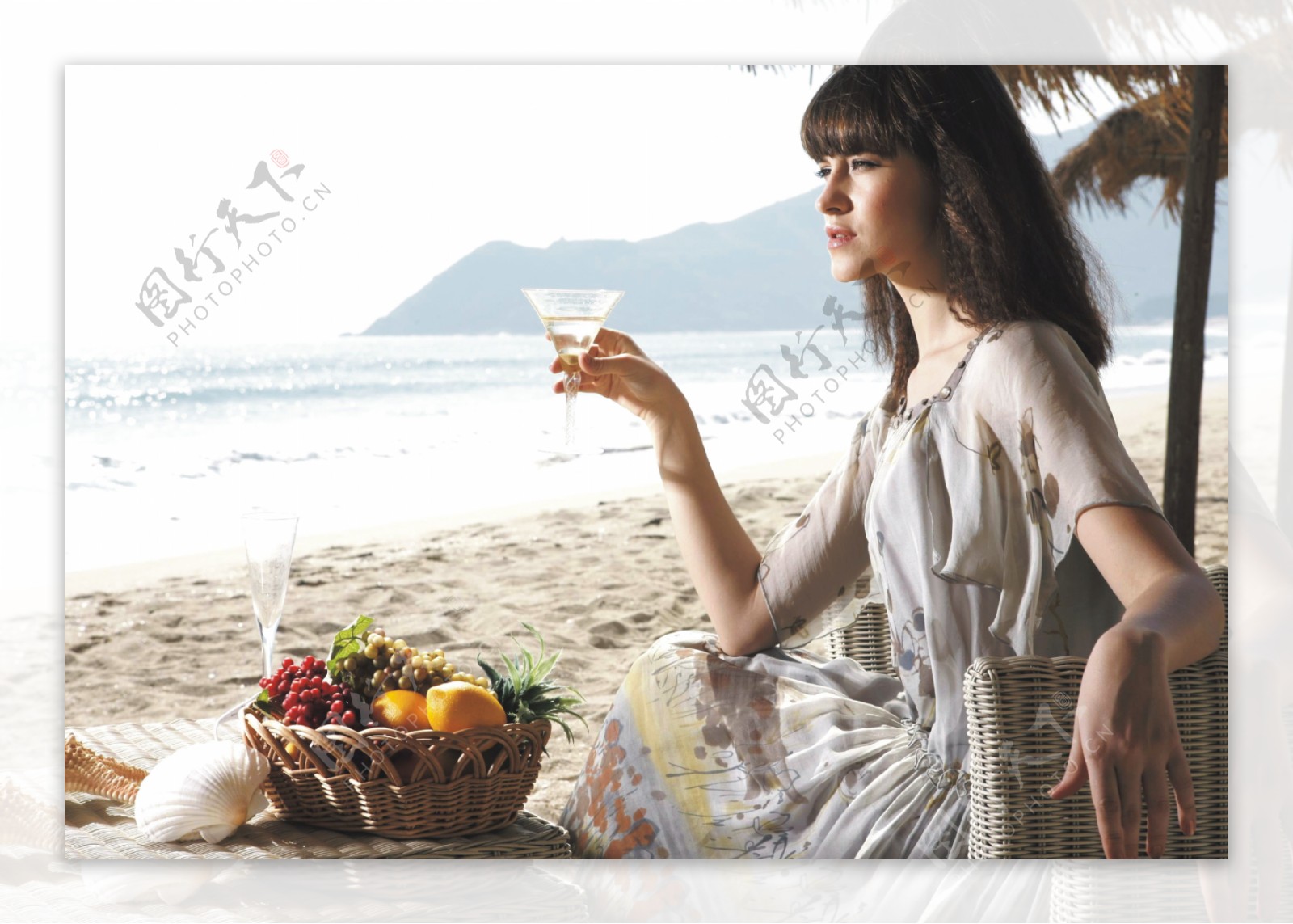 沙滩上喝酒休闲的美女图片