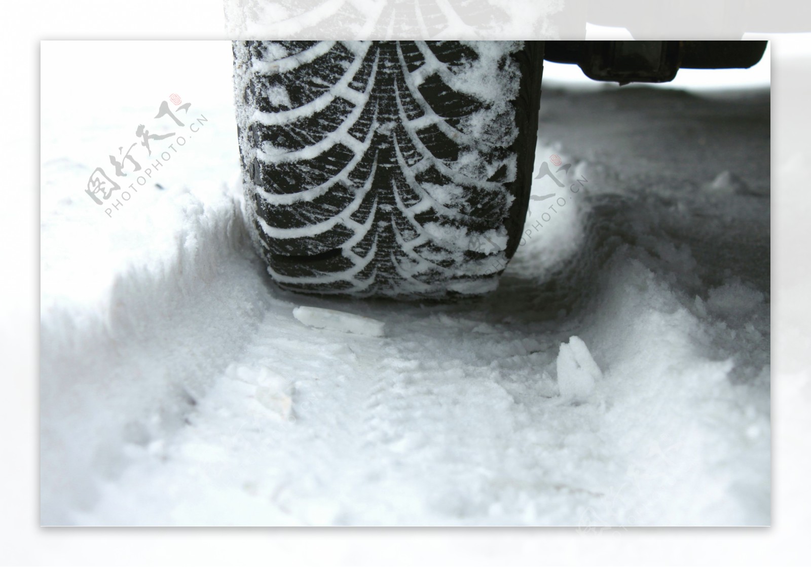 行驶在堆满雪的马路上的车图片