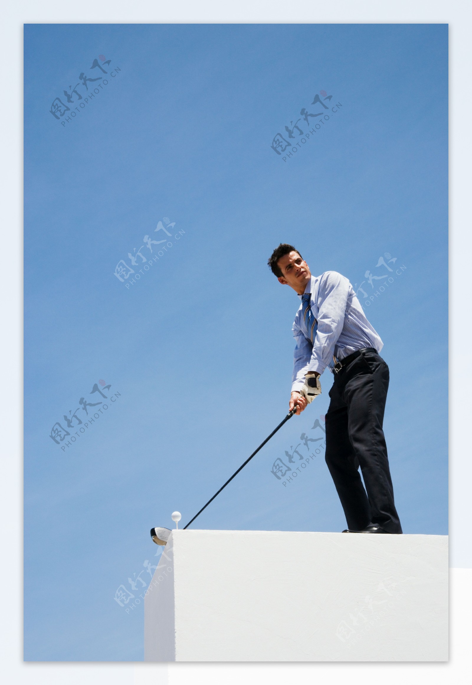 站在高处打高尔夫球的商务男士图片