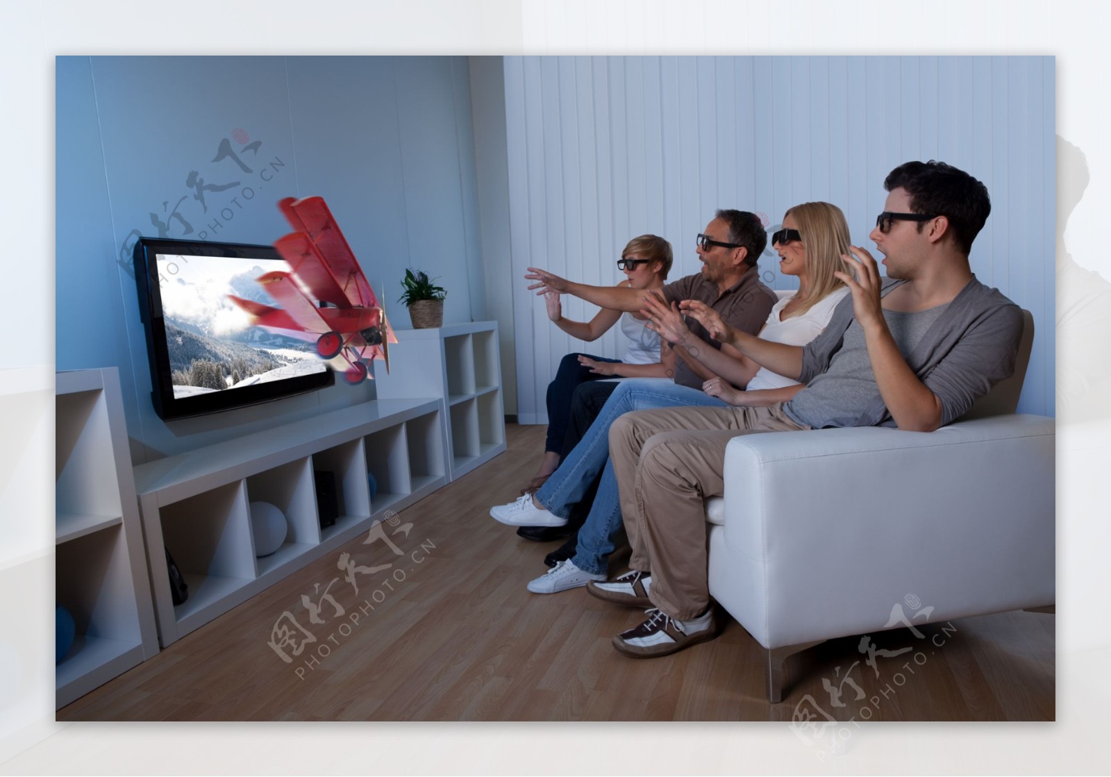 带着3D眼镜看电视的人们图片