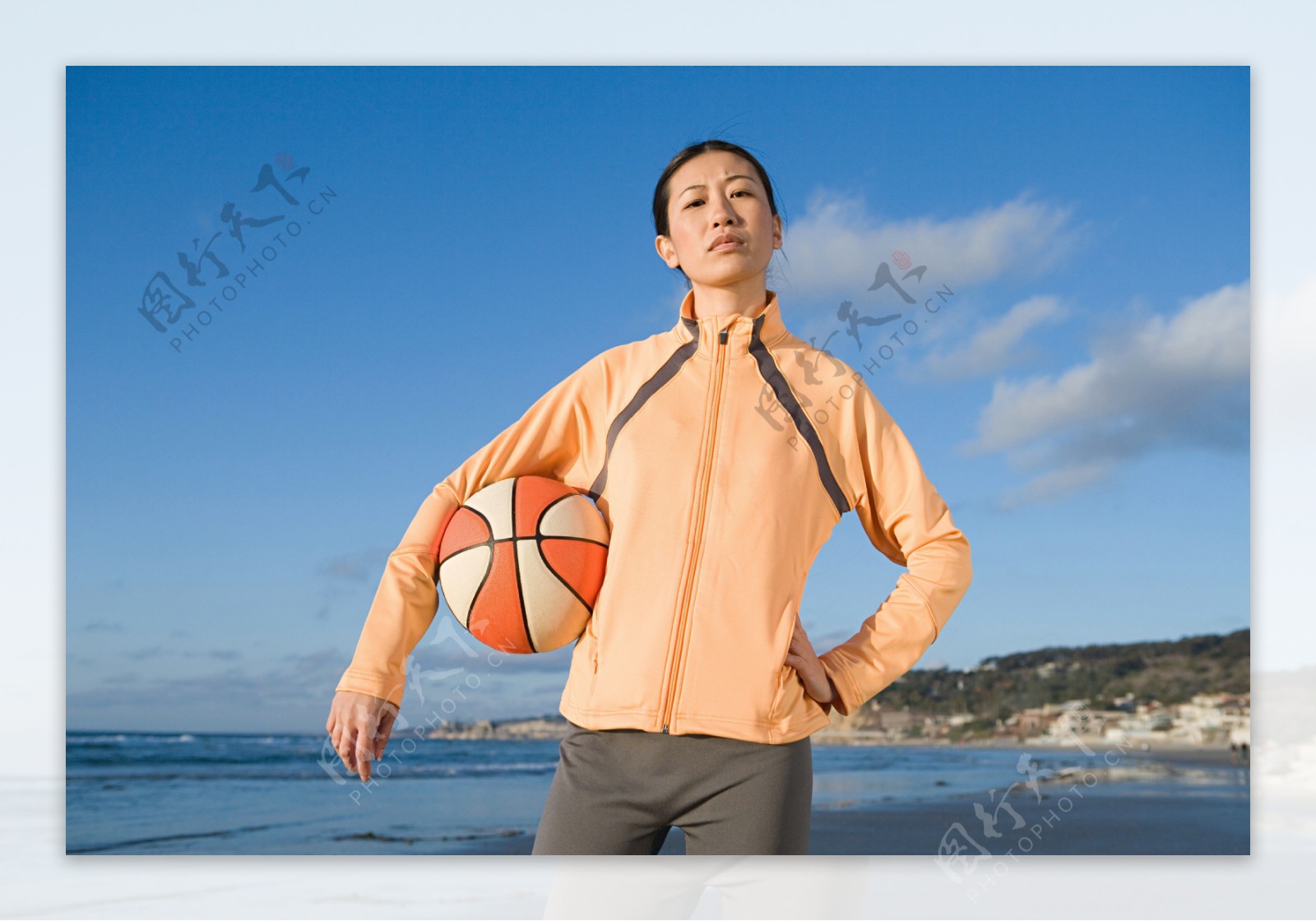 海边拿篮球的女人图片