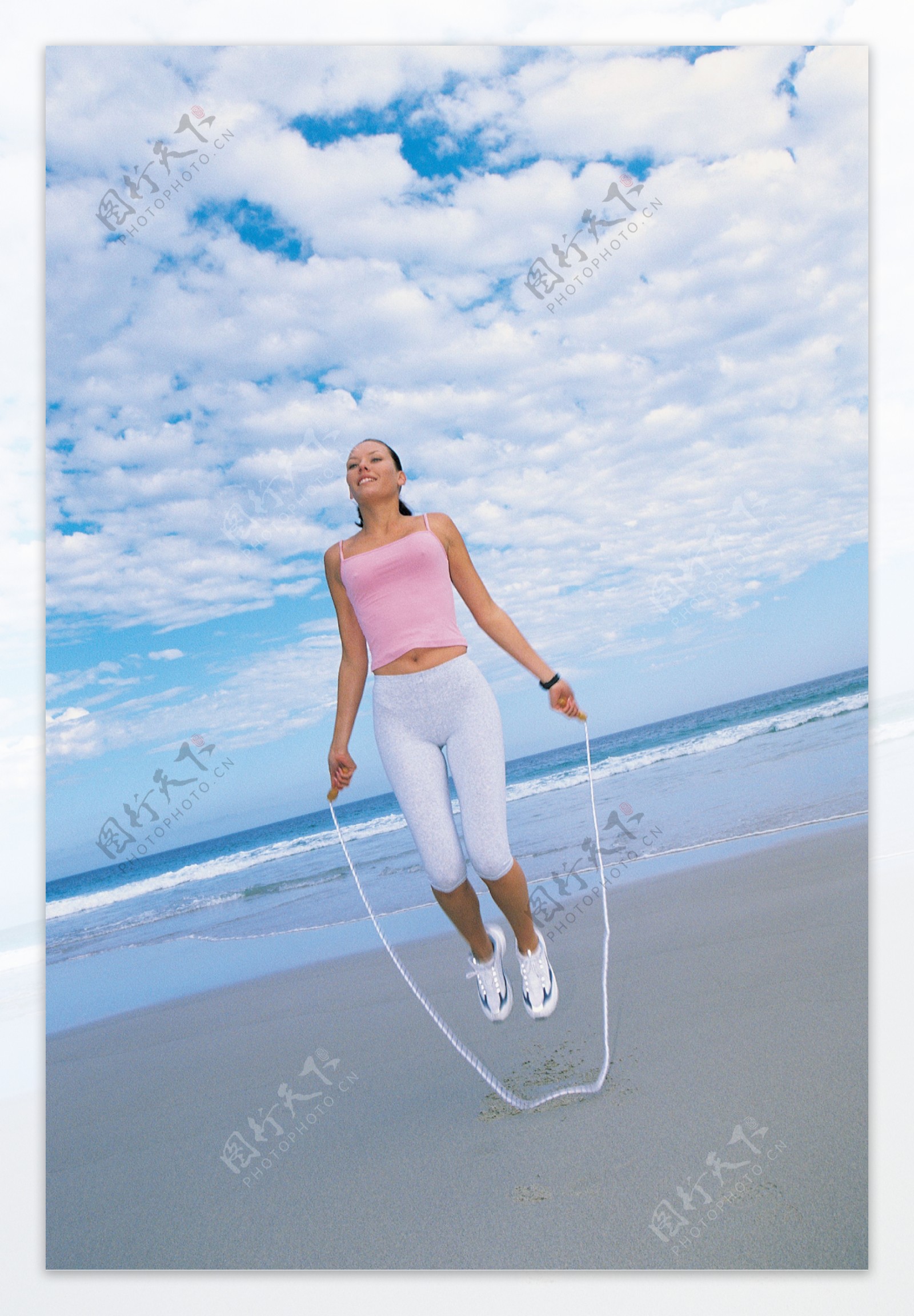 海滩上跳绳的美女图片