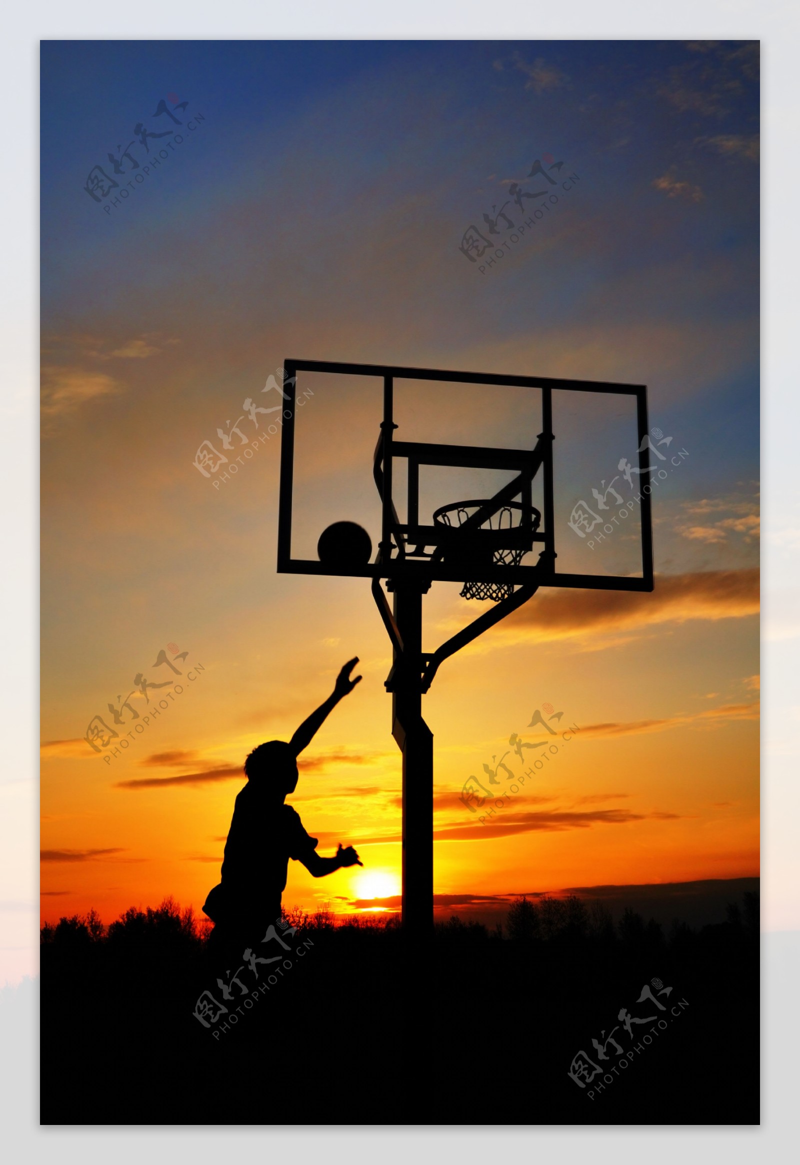 夕阳下投篮的运动员图片