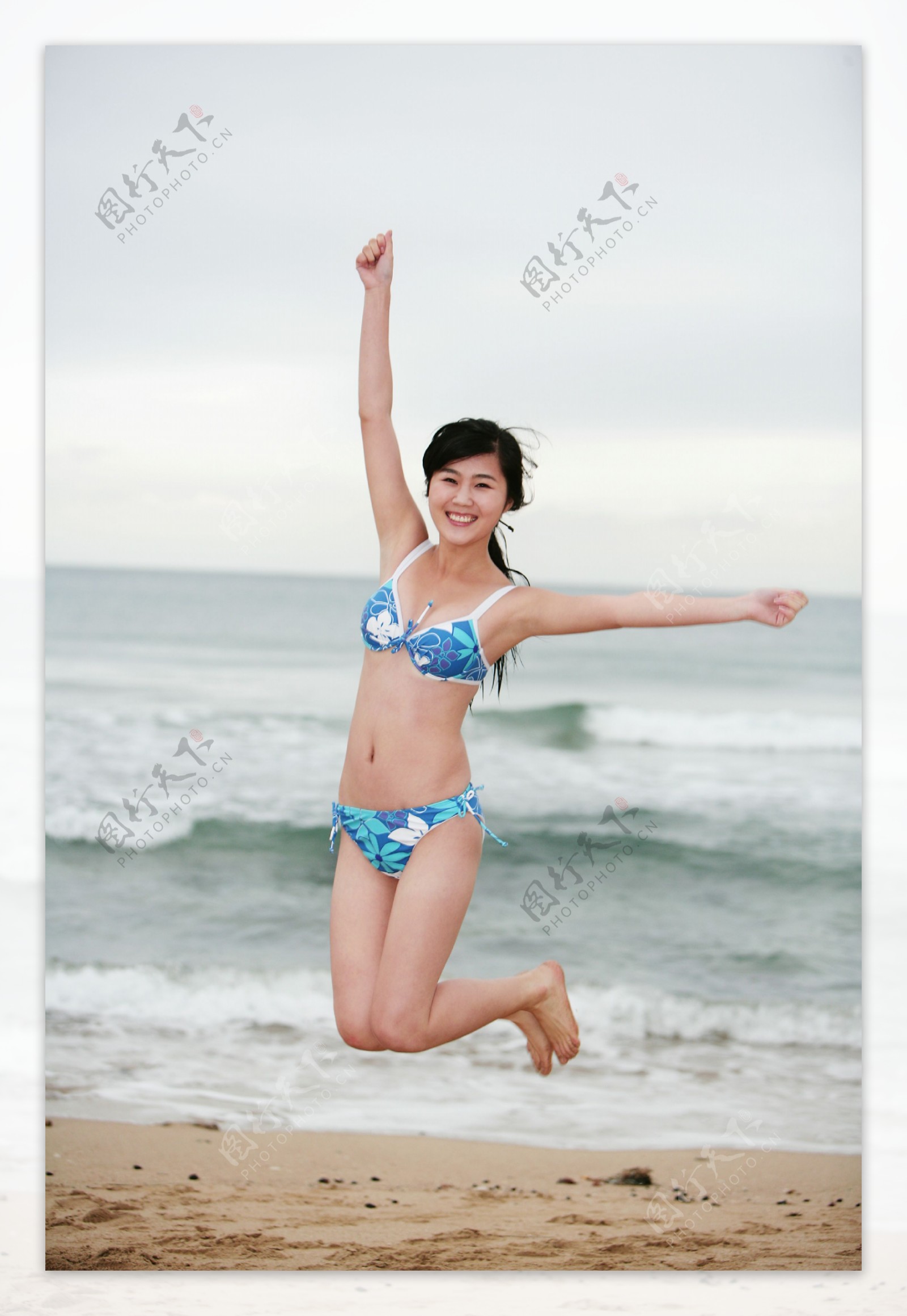 沙滩跳跃的美女图片