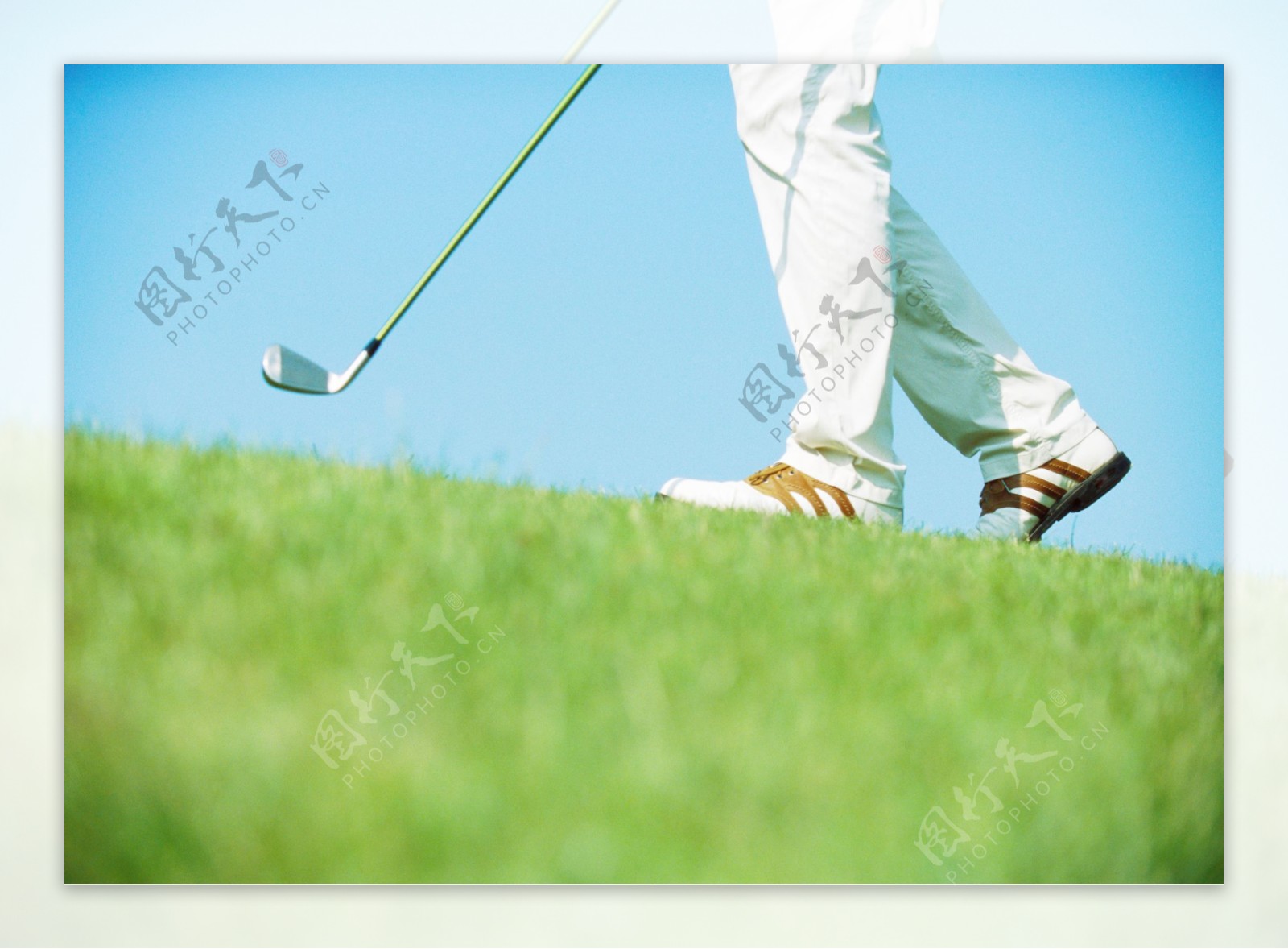 草地上高尔夫球棒脚部特写图片