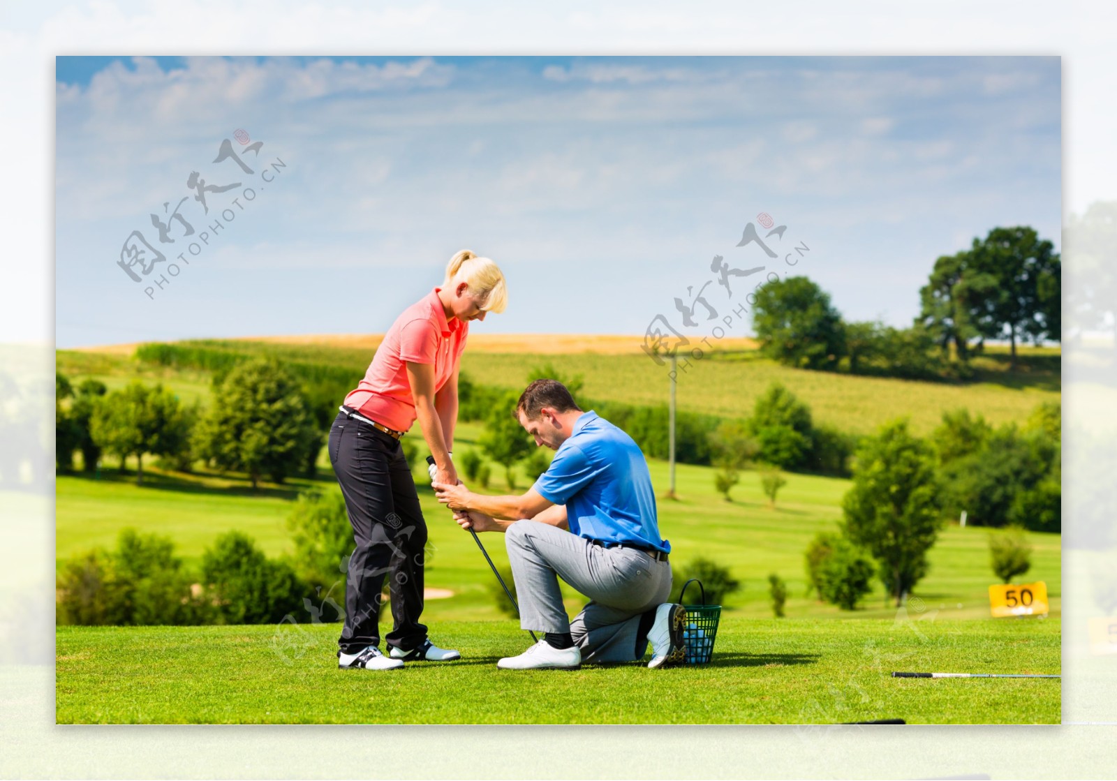 草地外国男人教外国女人打高尔夫球图片