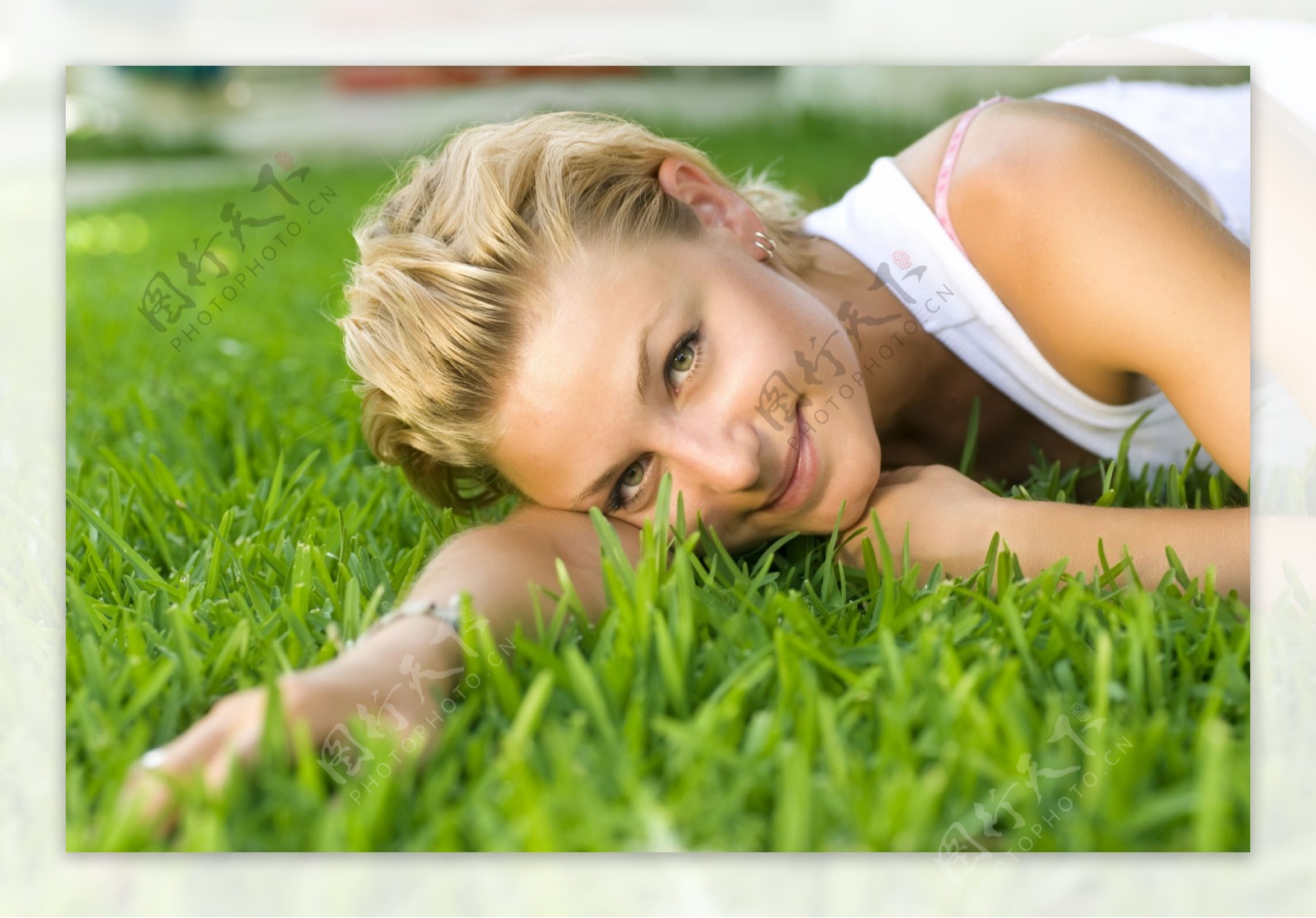 侧躺在草地上的美女图片