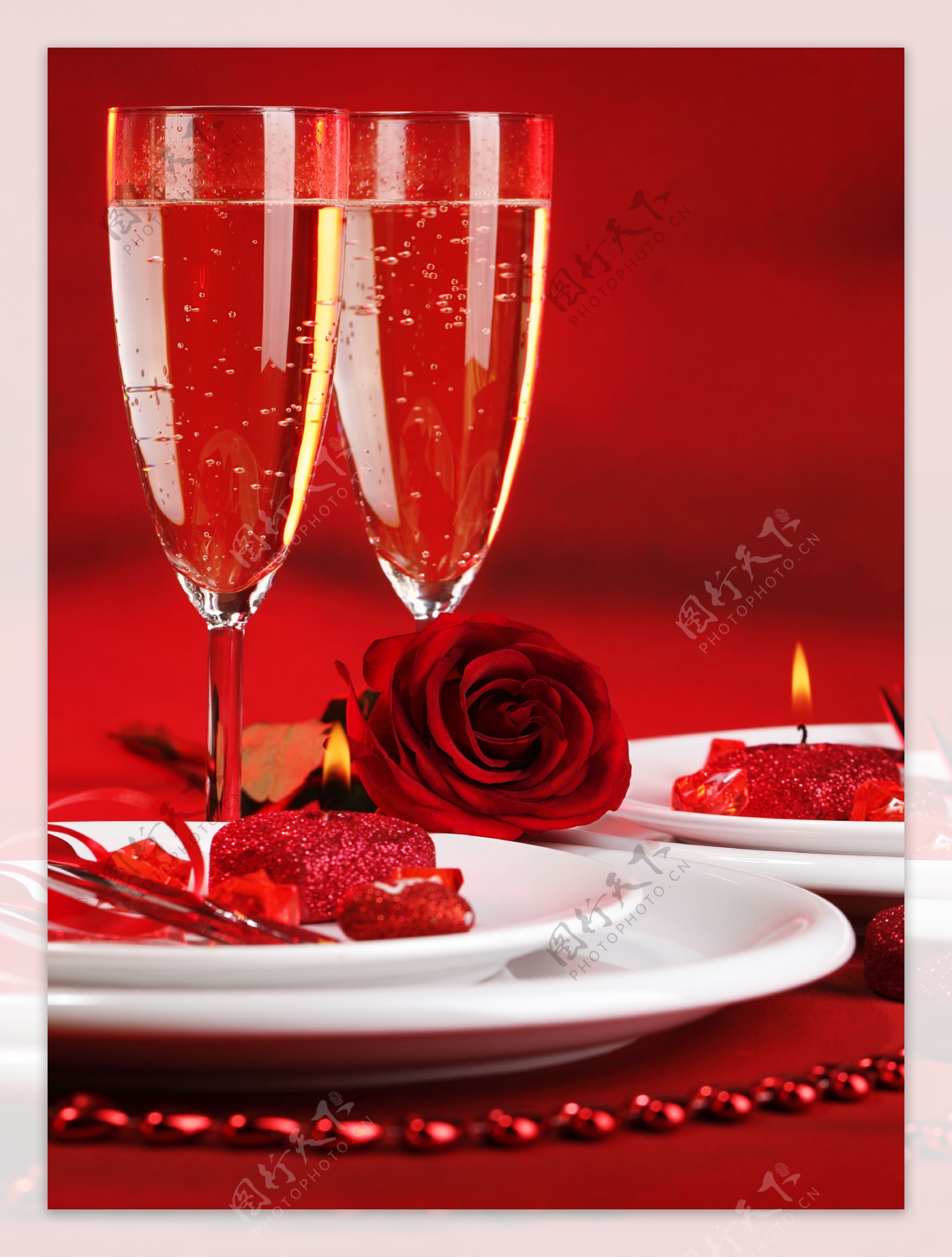 红色背景下的酒杯和玫瑰花