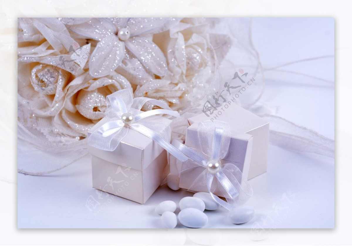 白色花朵前的礼物盒图片