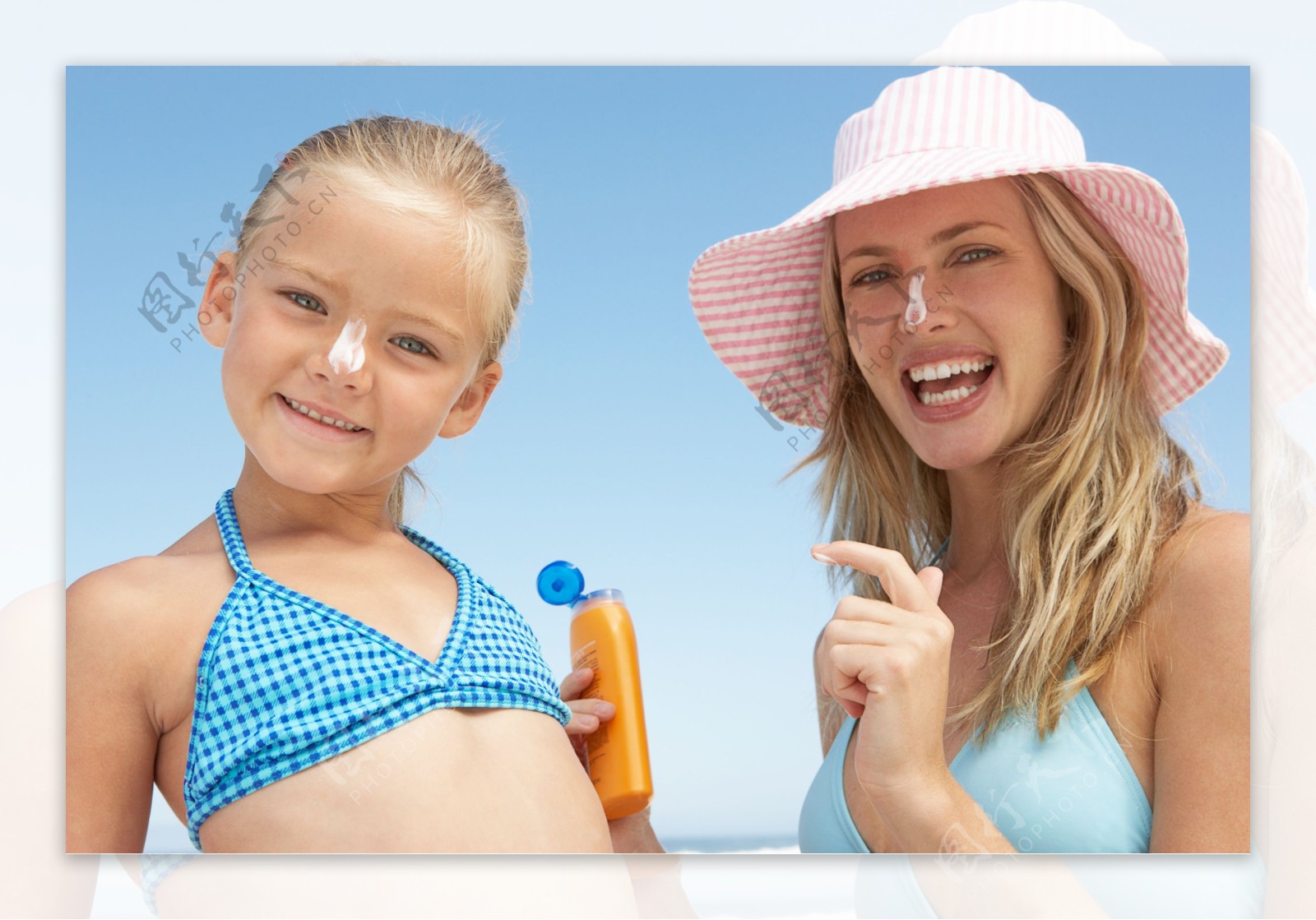 沙滩上擦防晒乳的母女图片