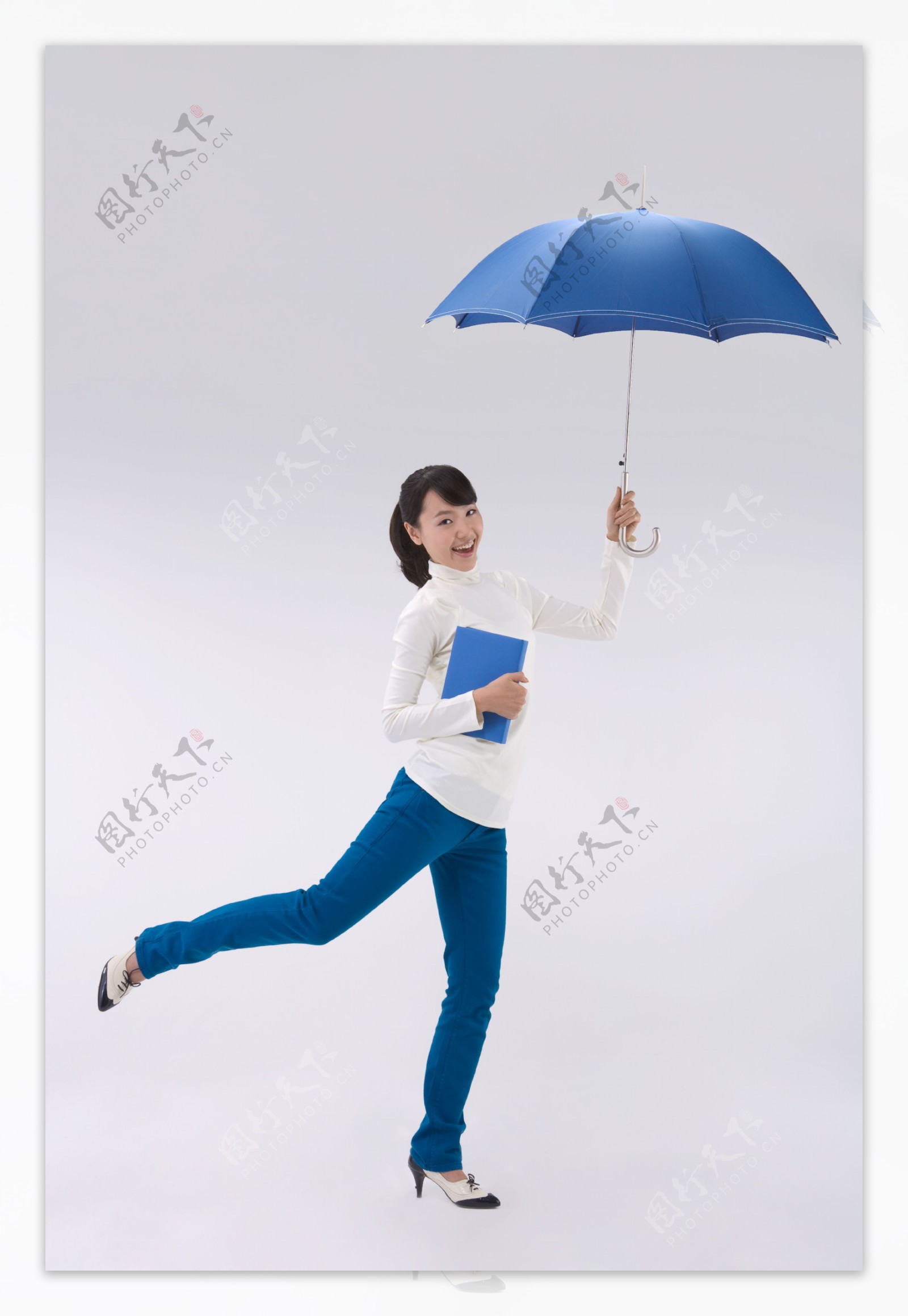 拿着一本书和雨伞的开心女孩图片
