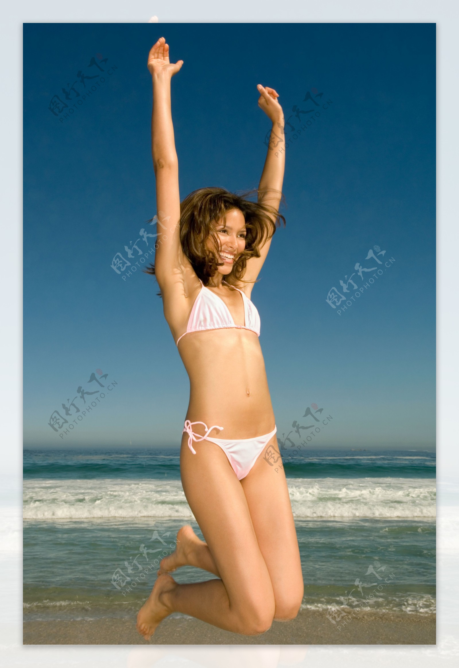 沙滩上跳跃的美女图片