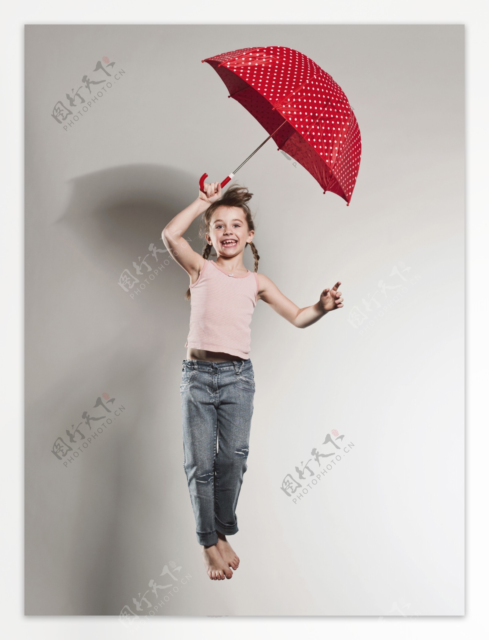 打雨伞跳跃的外国小女孩图片