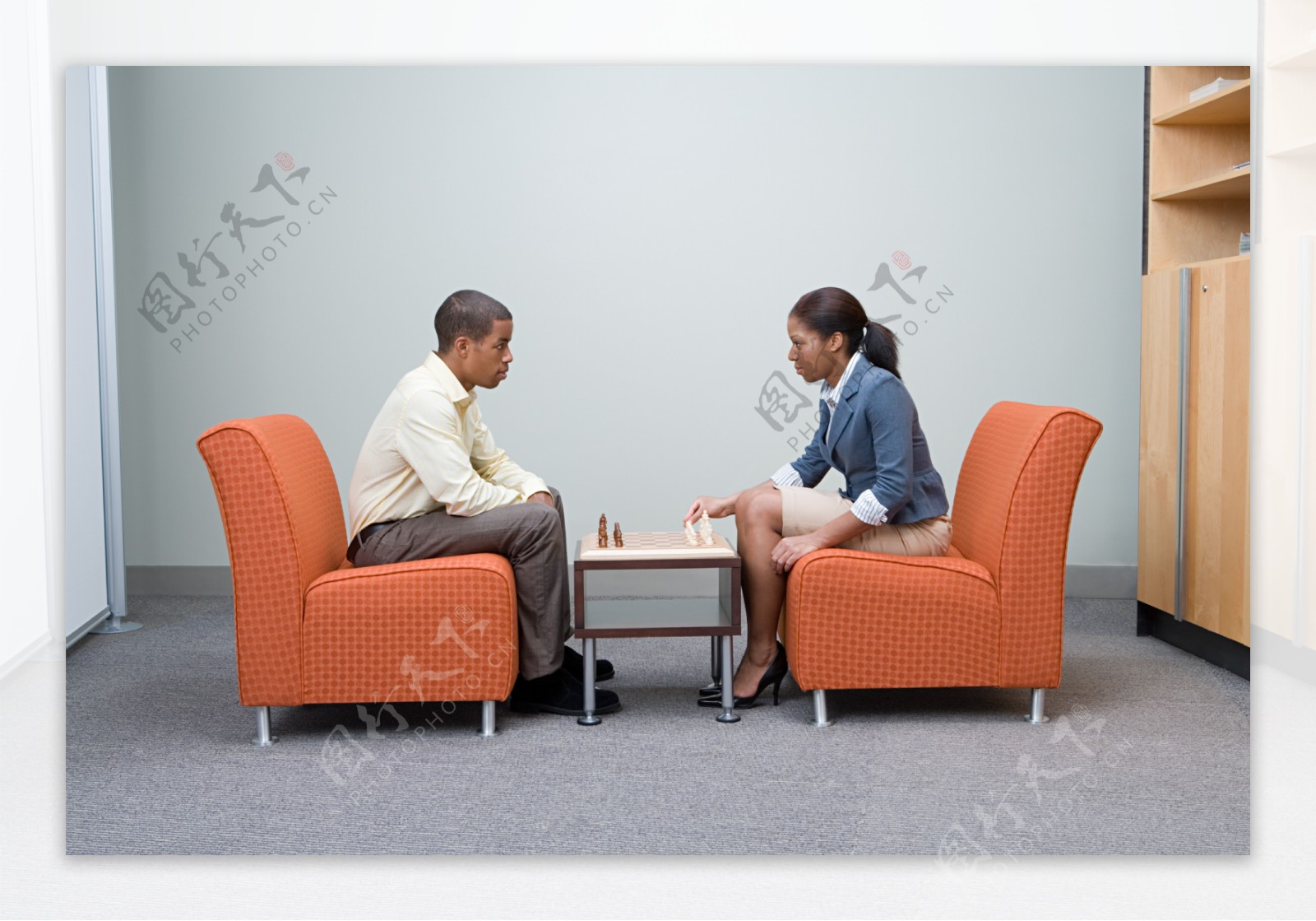 坐在沙发上下棋的商务男女图片