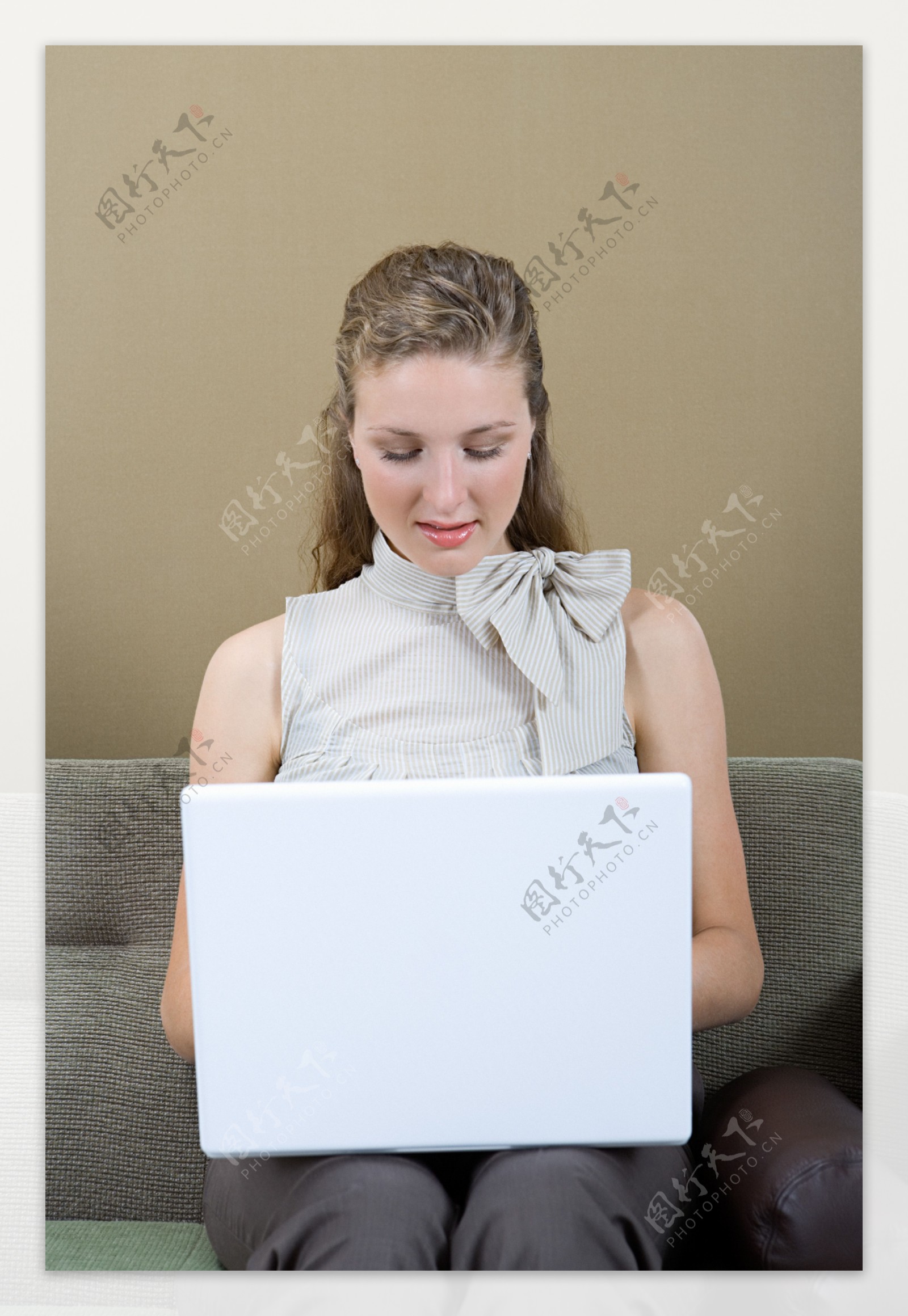 坐在沙发上玩电脑的女人图片