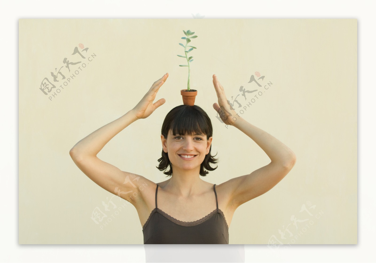 头顶上放着盆栽的女人图片