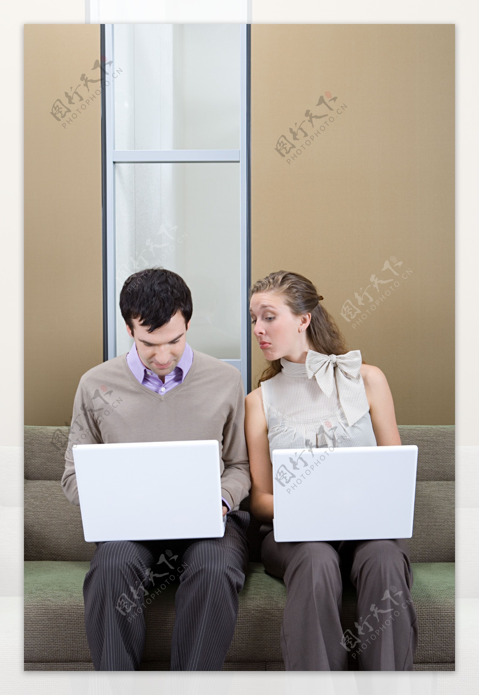 坐在沙发上玩电脑的男女图片
