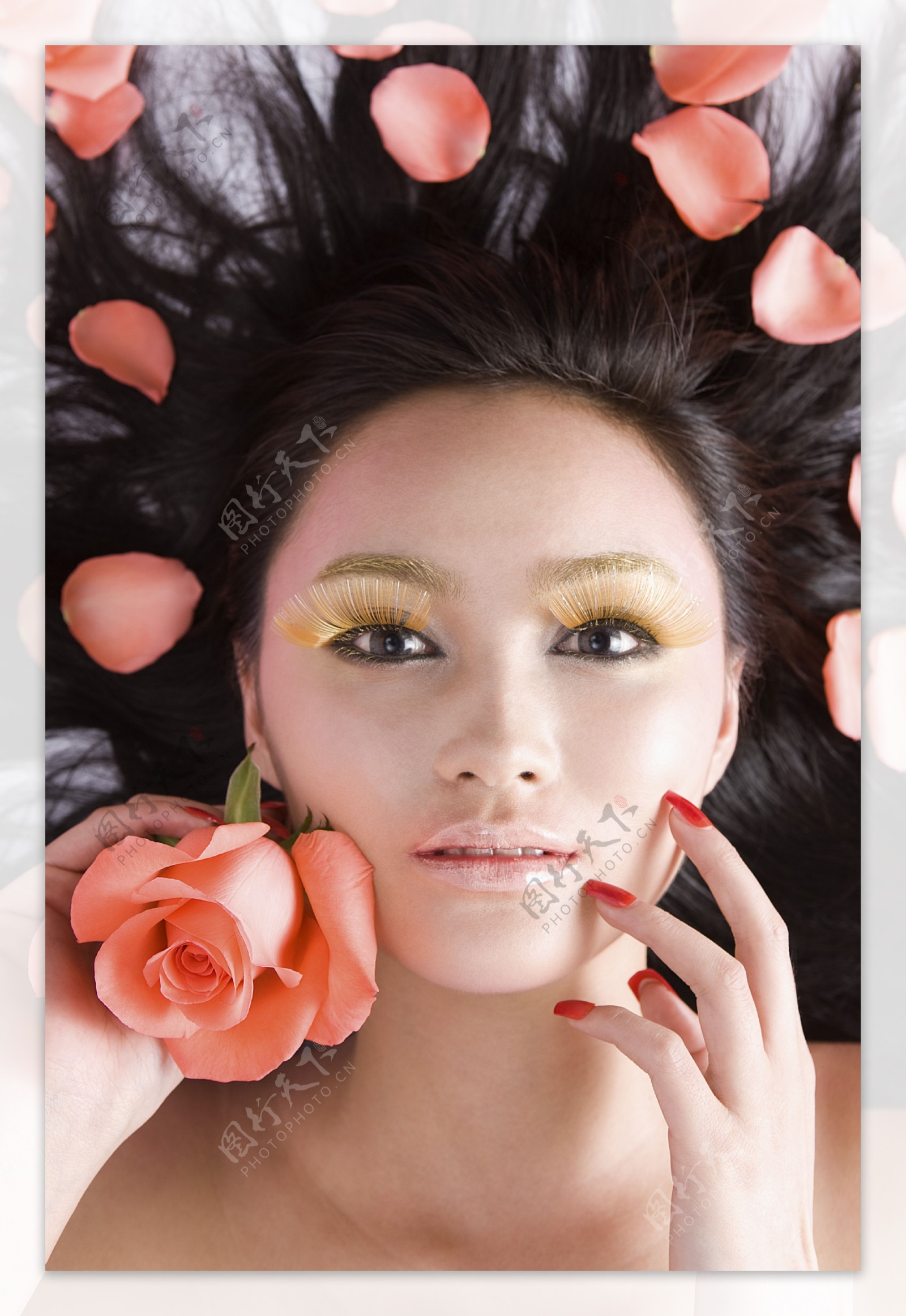 躺在花瓣中的化妆女人图片