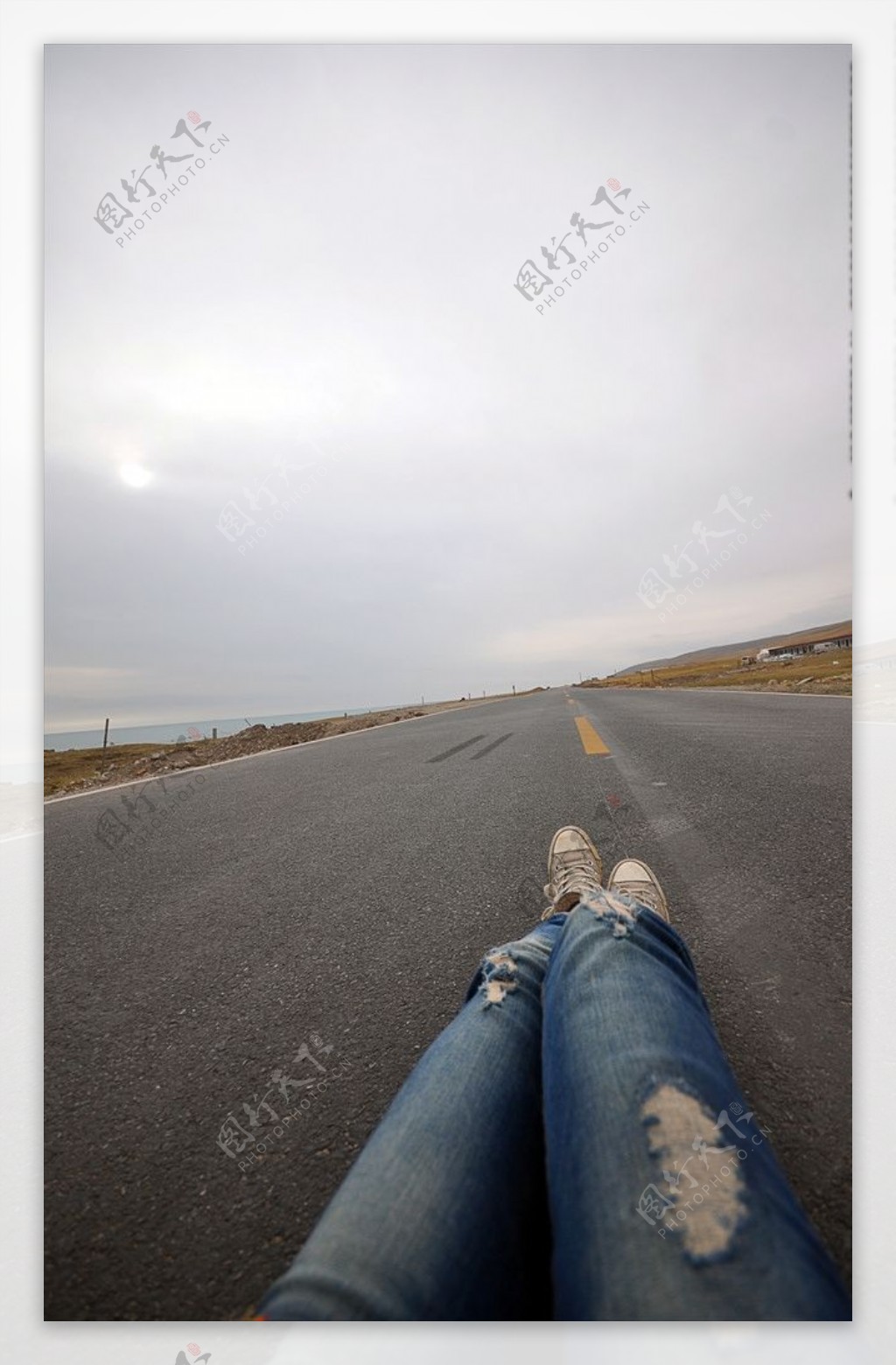 牛仔裤长腿躺在公路上